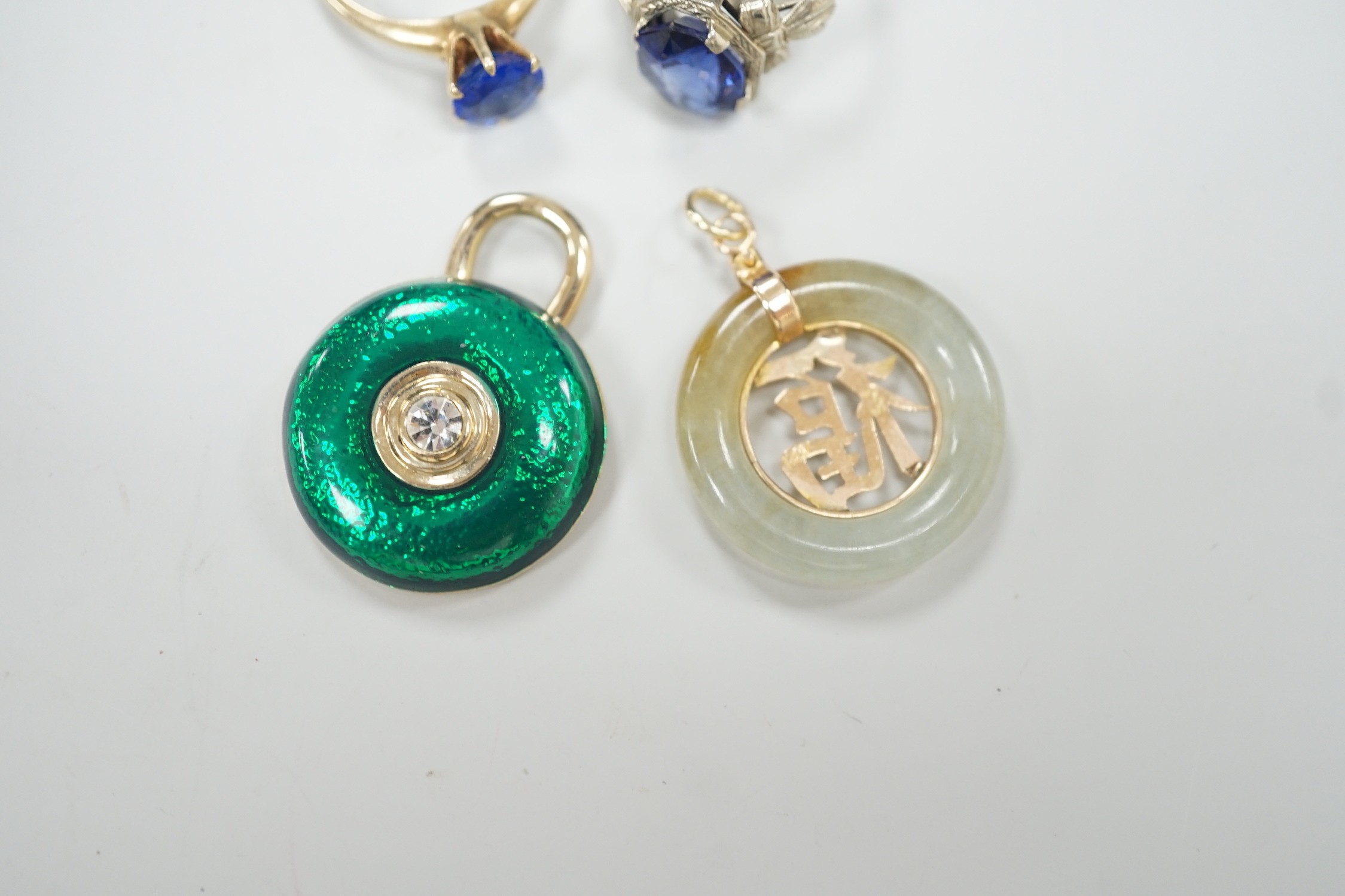 A 14k white metal and oval cut synthetic sapphire ring, a yellow metal and blue paste ring, a 585 yellow metal and jadeite pendant and a costume pendant.